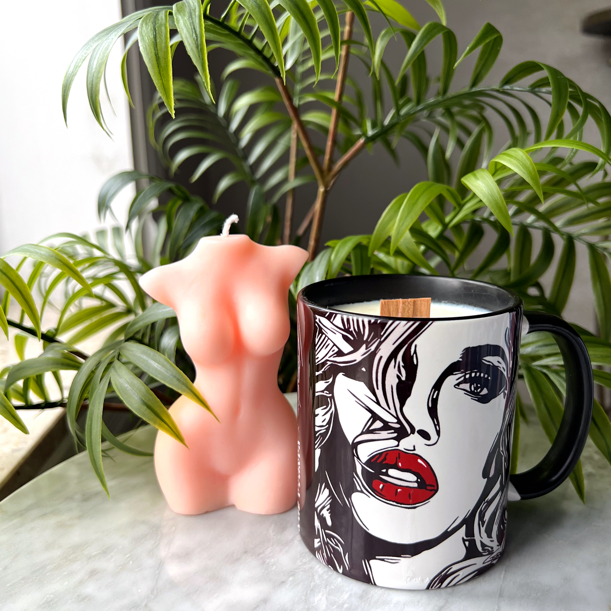 Black and white artwork coffee mug with soy wax scented candle and wood wick for mother's day. feminine body shape palm trees and marble table 